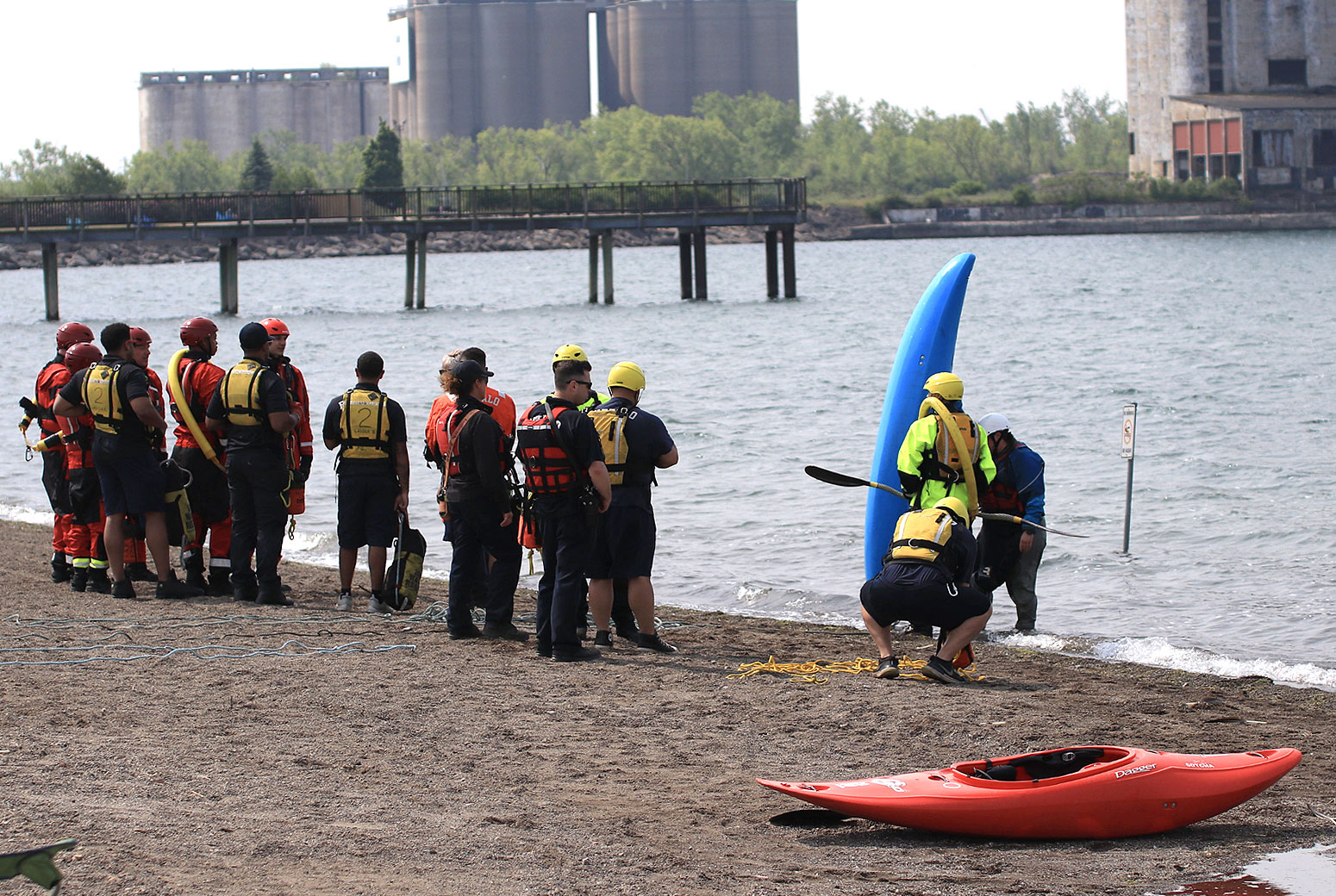 Water rescue team on the beach preparing kayaks for a rescue.