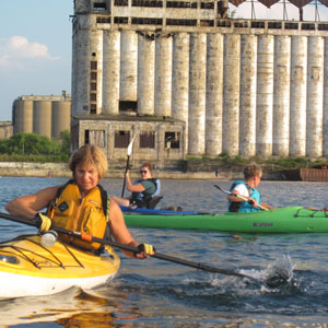 Group of kayakers paddling near cement silos