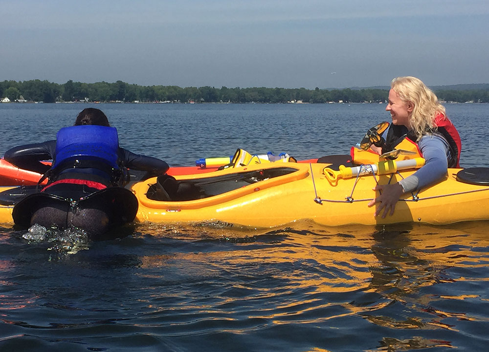 Two women in kayaks practicing overboard rescue