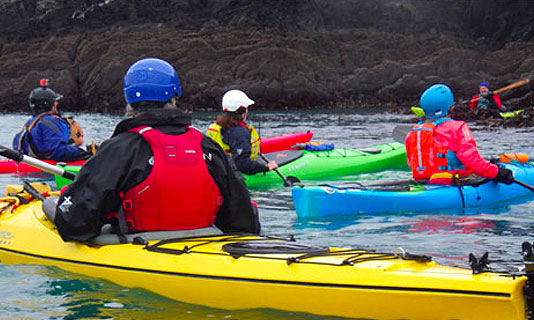 Group of paddlers in the water listing to instructor